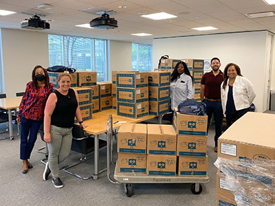 staff members with boxes of school supplies